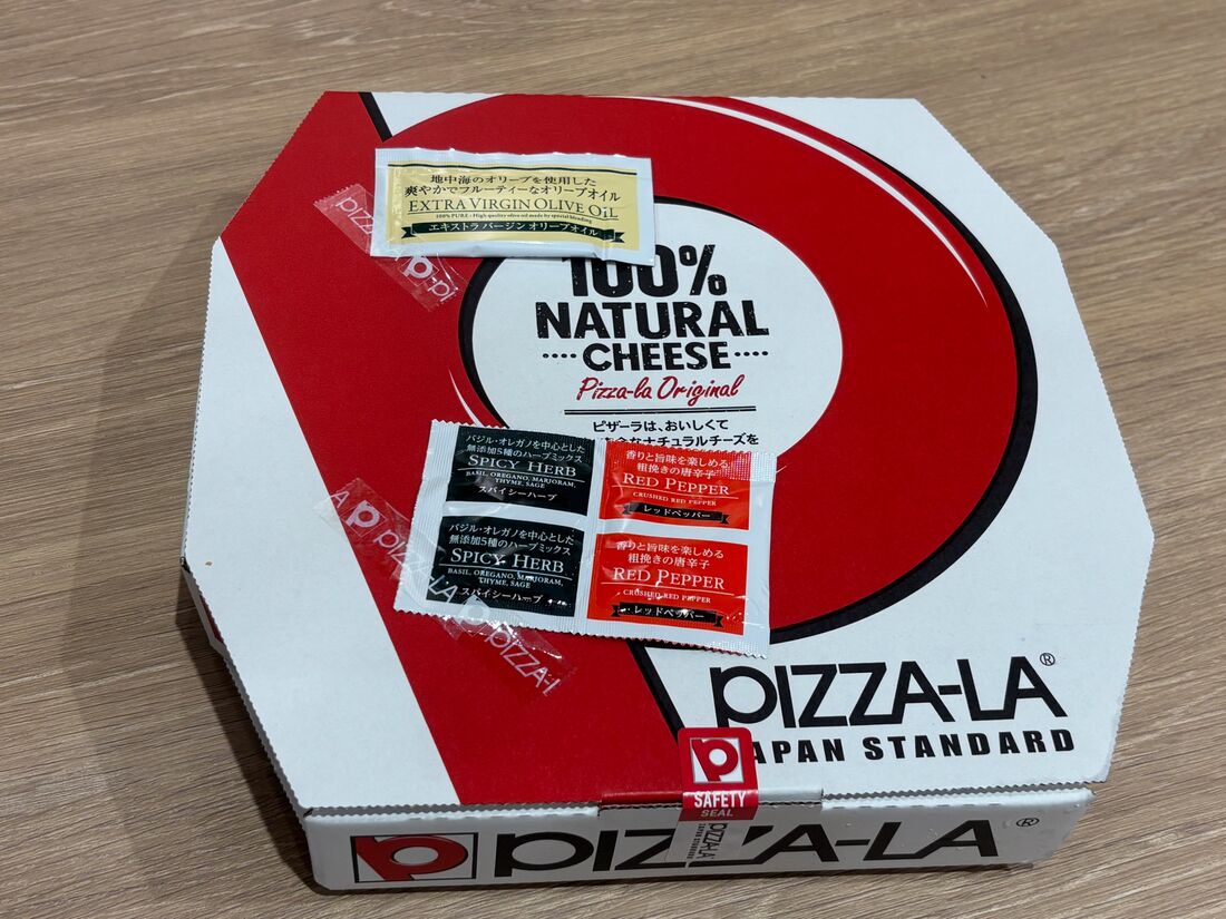 ピザの箱には、オリーブオイルとスパイスが付属されている