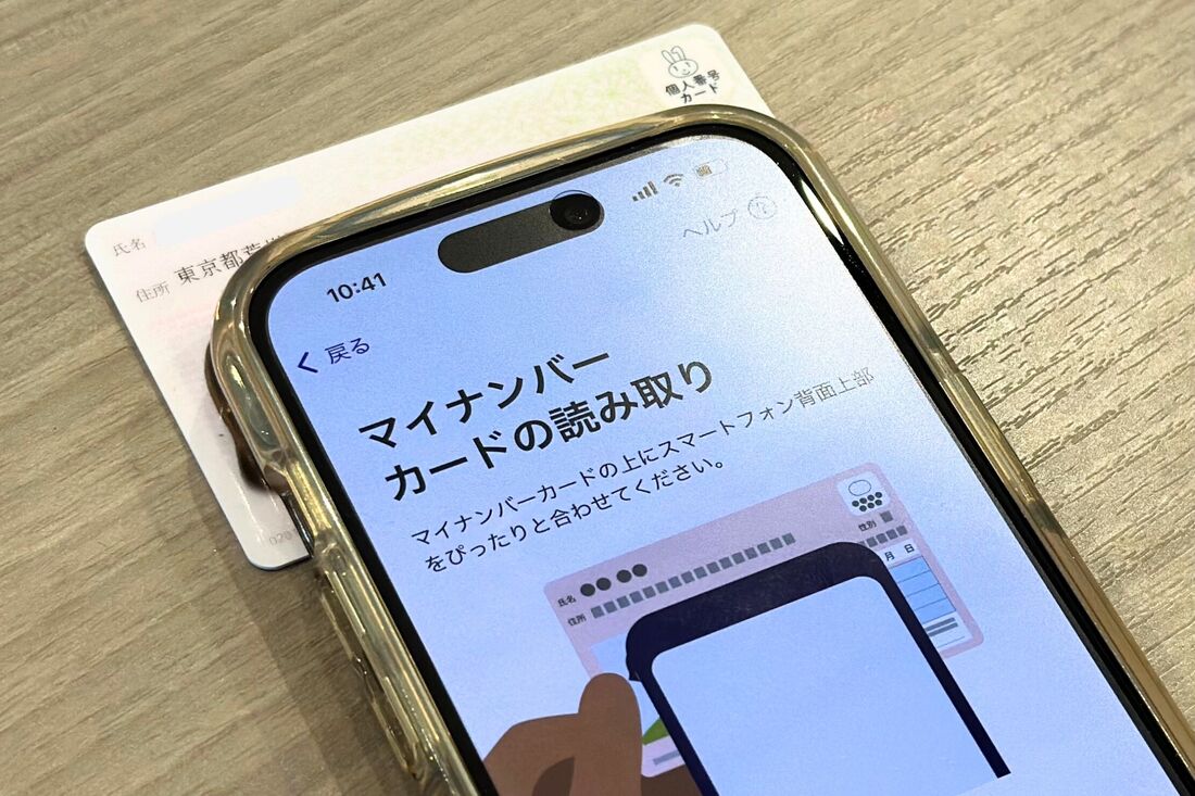 マイナンバーカードをスマホの背面上部にピッタリと付けて読み取る