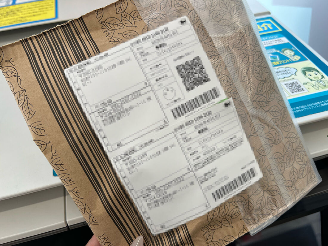 宛名ラベルをコードリーダーにかざし、荷物に貼る
