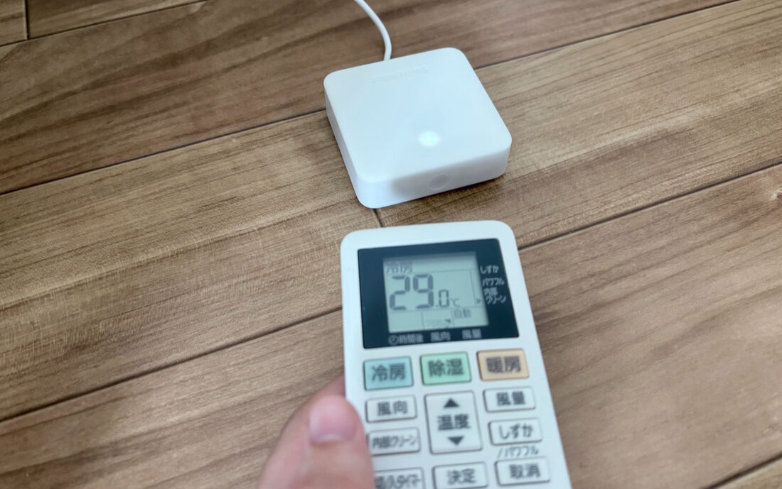 SwitchBotハブミニに向けてエアコンのリモコンを操作している